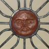 Hand forged window grate with copper sun face.